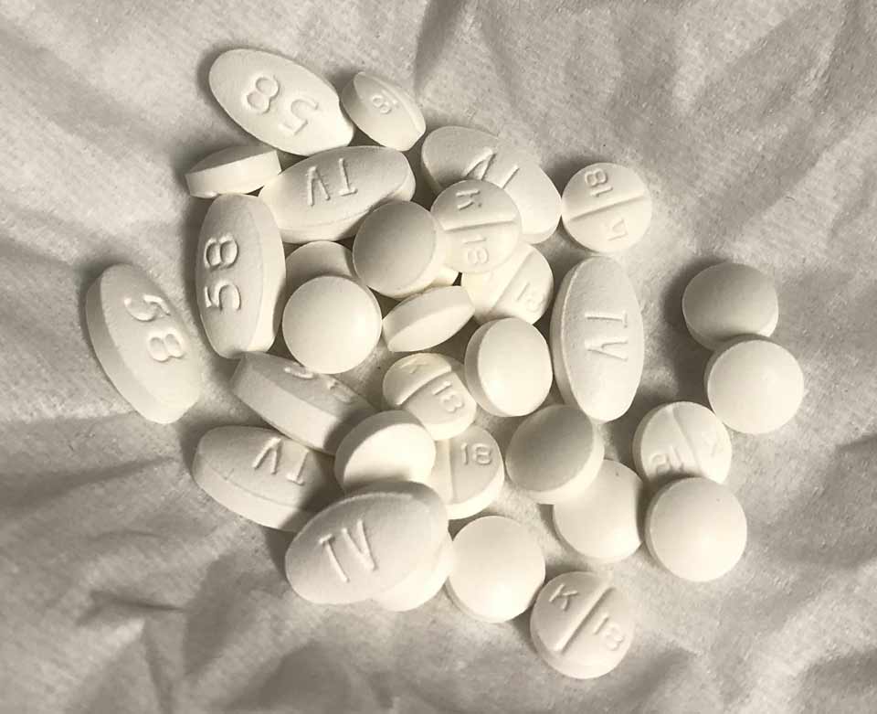 TV 58 tramadol 50 mg white oval tablet on a pharmacy counter